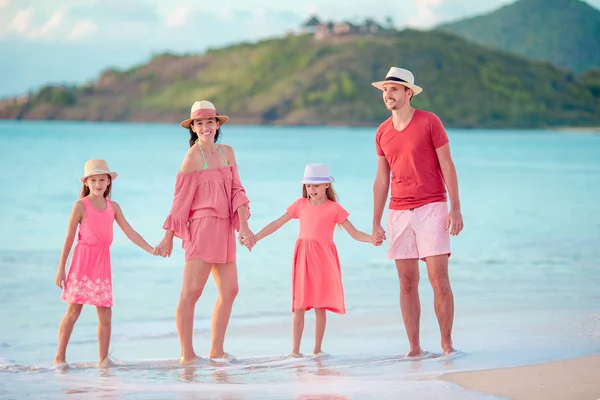 愉快的家庭与孩子在海滩漫步在日落 — 图库照片