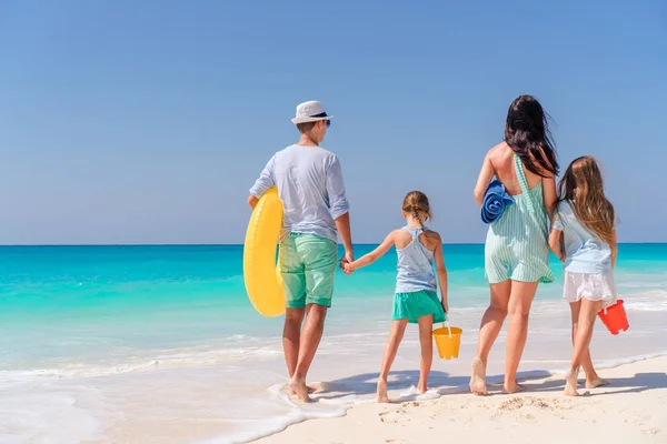 Família feliz com crianças caminham na praia ao pôr do sol — Fotografia de Stock