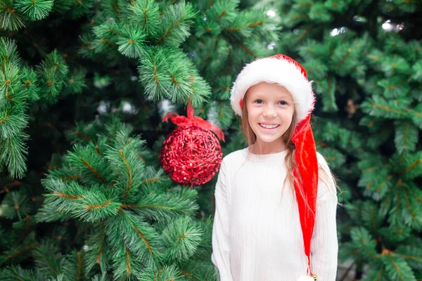 Pequena menina feliz perto do ramo de abeto na neve do Ano Novo . — Fotografia de Stock