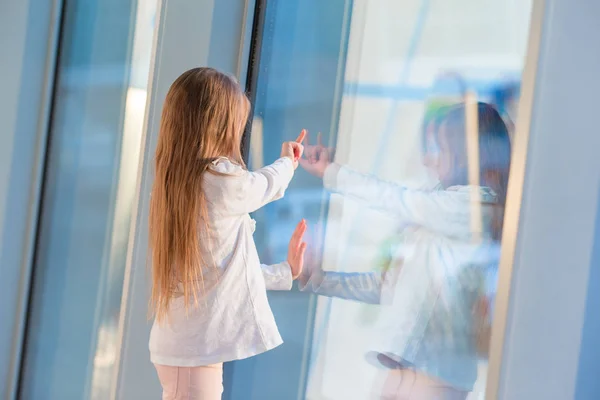 Niña en el aeropuerto cerca de la ventana grande mientras espera el embarque — Foto de Stock