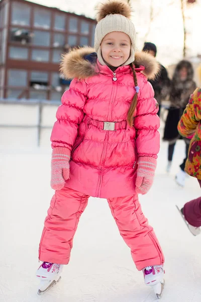 Entzückendes kleines Mädchen genießt Schlittschuhlaufen auf der Eisbahn — Stockfoto