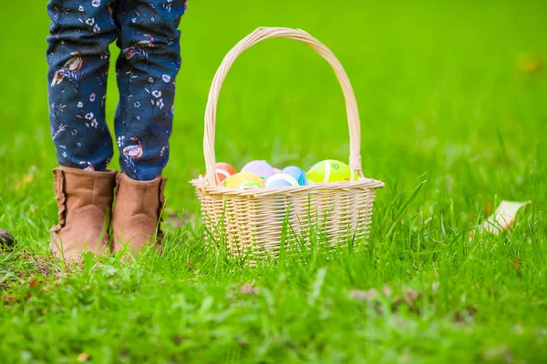 Close up colorful Easter eggs in a basket on the grass — Stock Photo, Image