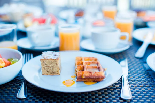 Sałatki ze świeżych owoców, gofry, ciasta, kawa i sok serwowane śniadanie w restauracji resort — Zdjęcie stockowe
