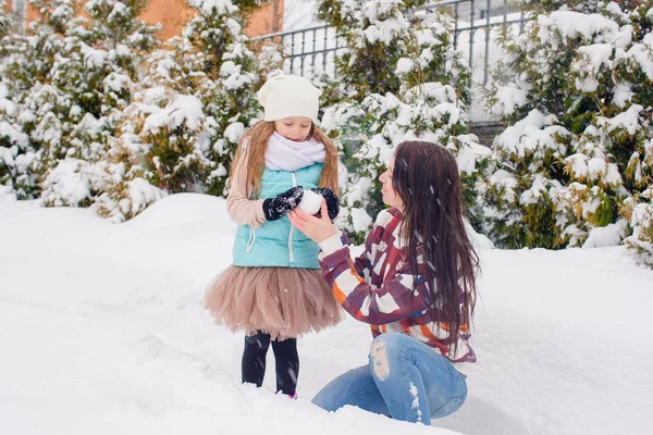 Счастливая семья мамы и малыша наслаждается зимним снежным днем — стоковое фото