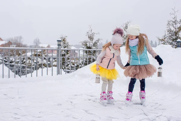 Adorable niñas patinaje en pista de hielo al aire libre en invierno día de nieve — Foto de Stock