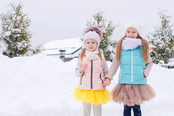 Schattige meisjes schaatsen op de ijsbaan buiten in de sneeuw winterdag — Stockfoto