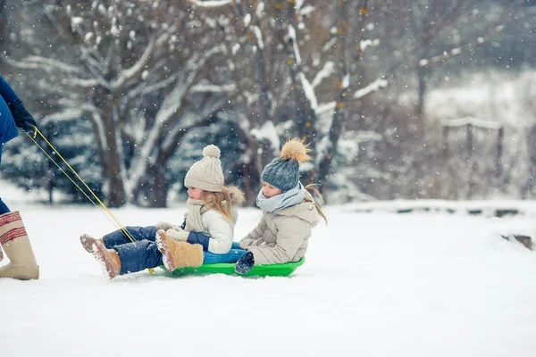 Очаровательные маленькие счастливые девочки катаются на санках в зимний снежный день . — стоковое фото