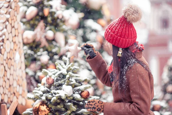 Lycklig flicka nära granen gren i snö för nytt år. — Stockfoto