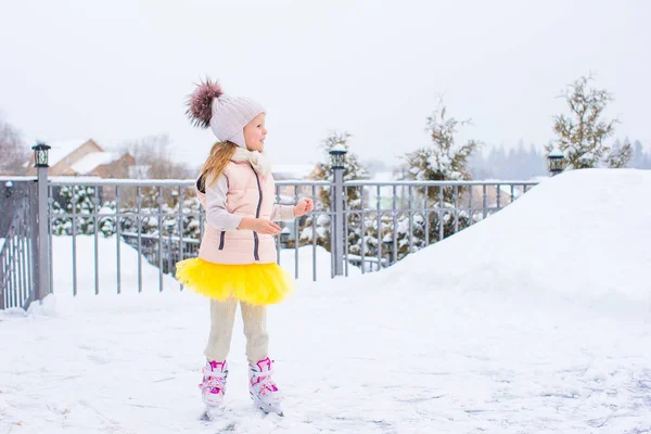 Adorable fille patiner sur la patinoire à l'extérieur en hiver journée de neige — Photo