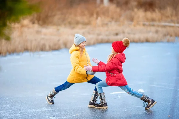 Adorables filles patinant sur la patinoire à l'extérieur en hiver journée de neige — Photo