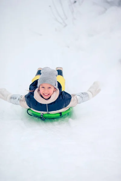 Adorable little happy girl sledding in winter snowy day. — Stock Photo, Image