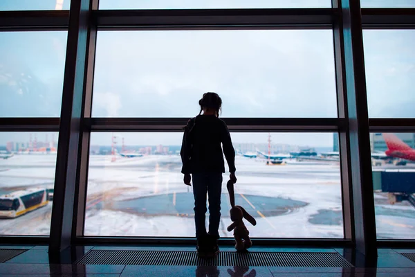 Niña en el aeropuerto cerca de la ventana grande mientras espera el embarque —  Fotos de Stock