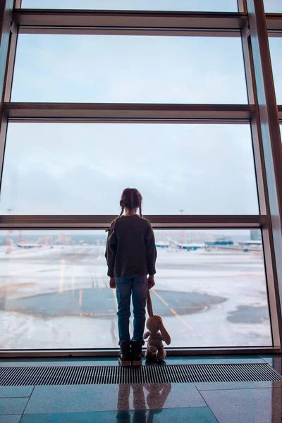 Niña en el aeropuerto cerca de la ventana grande mientras espera el embarque — Foto de Stock