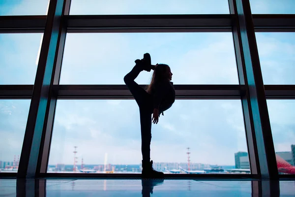 Menina no aeroporto perto de uma grande janela enquanto espera pelo embarque — Fotografia de Stock