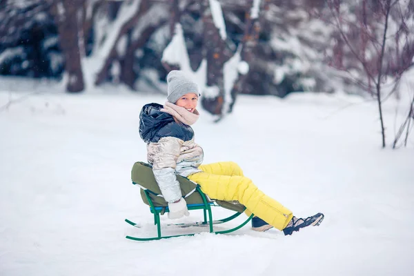Adorabile piccola ragazza felice slittino in inverno giorno nevoso . — Foto Stock