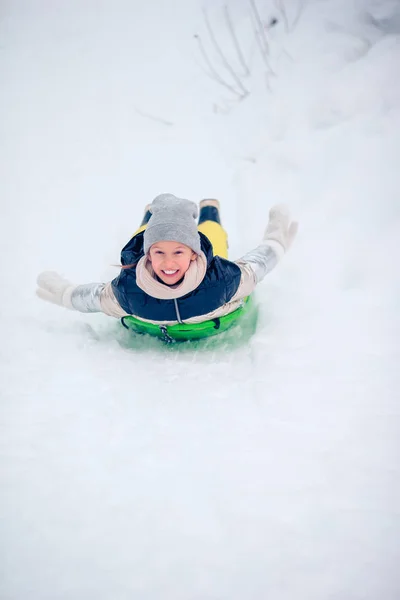 Adorable little happy girl sledding in winter snowy day. — Stock Photo, Image