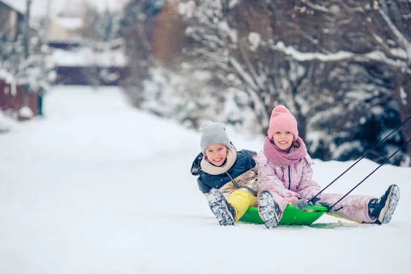 Adorable petite fille heureuse luge en hiver journée enneigée . — Photo