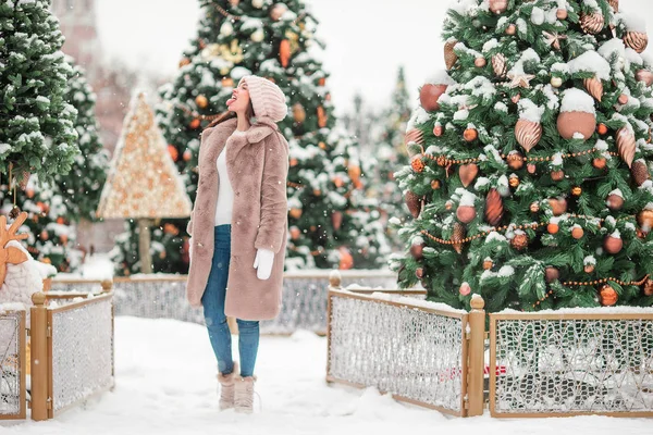 Mutlu kız yılbaşı için karların içinde köknar ağacı dalının yanında.