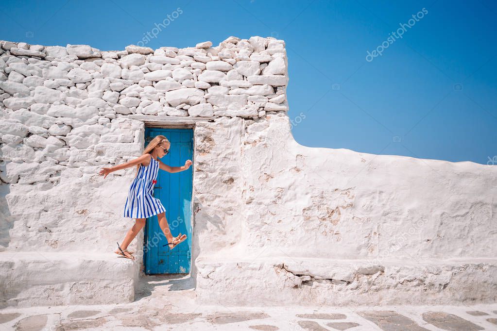 Girl in blue dresses having fun outdoors on Mykonos streets