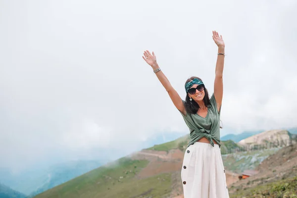 Beautiful happy young woman in mountains in the background of fog — Stock Photo, Image