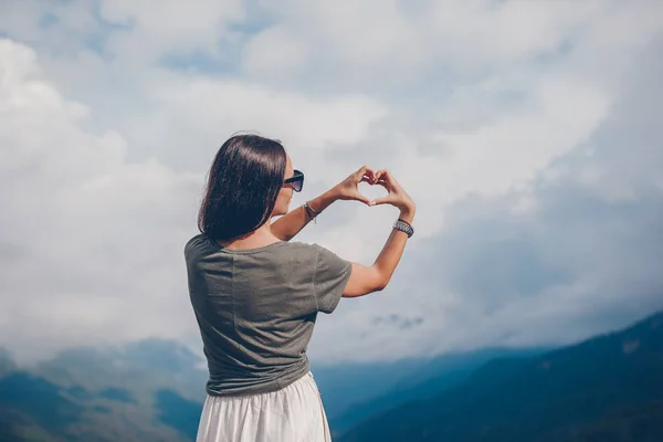 Mulher jovem feliz bonita em montanhas no fundo do nevoeiro — Fotografia de Stock