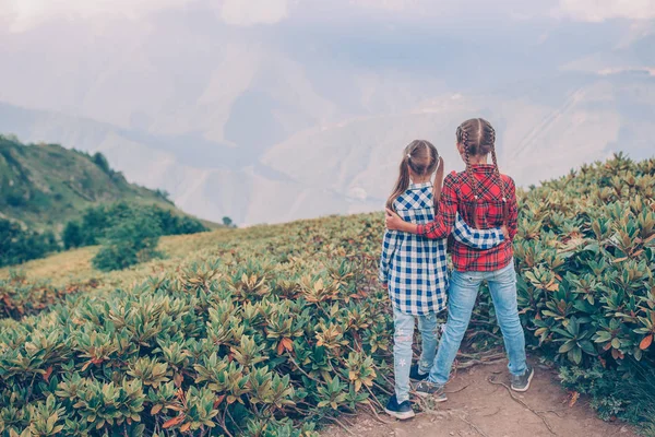 Beautiful happy little girls in mountains in the background of fog — Stock Photo, Image