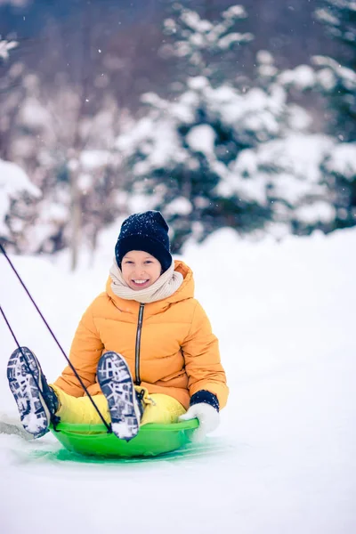 Adorable little happy girl sledding in winter snowy day. — Stock Photo, Image