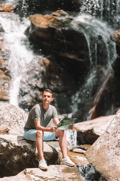 Man enjoying view of waterfall in gungle — Stock Photo, Image