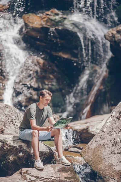 Man enjoying view of waterfall in gungle — Stock Photo, Image