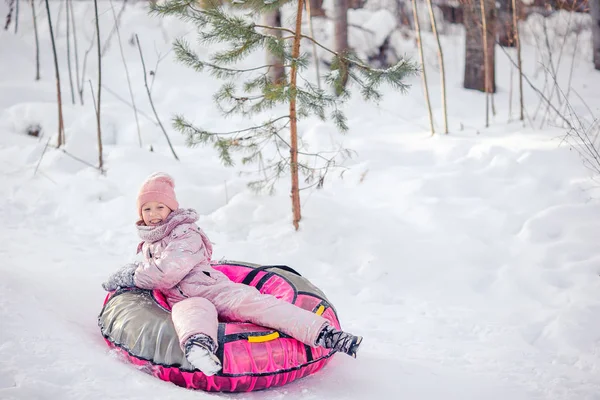 Adorable little happy girl sledding in winter snowy day. — Stock Photo, Image