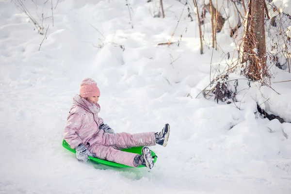 Adorable little happy girl sledding in winter snowy day. — Stock Photo, Image