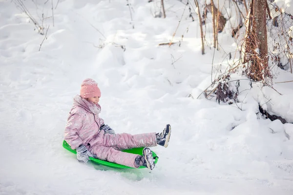 Adorable petite fille heureuse luge en hiver journée enneigée . — Photo