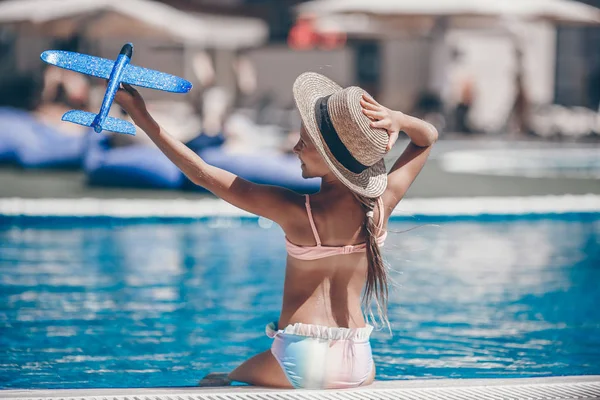 Hermosa niña divirtiéndose cerca de una piscina al aire libre — Foto de Stock