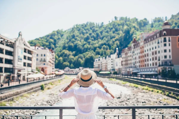 Szczęśliwa dziewczyna o kapelusz na nabrzeże rzeki górskie europejskie miasto. — Zdjęcie stockowe