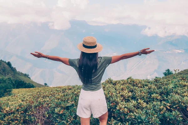 Mulher jovem feliz bonita em montanhas no fundo do nevoeiro — Fotografia de Stock