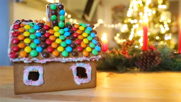 Pepparkaksälva hus på en bakgrund av ljusa julgran med krans — Stockvideo