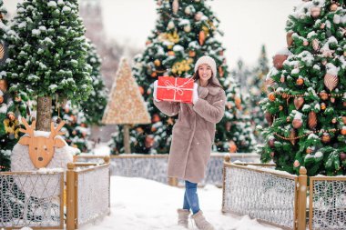 Yeni yıl hediye Noel ağacı bir harika kış günü açık havada karda yakınındaki güzel kadınla