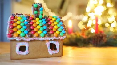 Çelenkli parlak Noel ağacının arka planında zencefilli kek evi