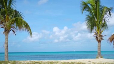 Idyllic plajı beyaz kum, turkuaz okyanus suyu ve mavi gökyüzü