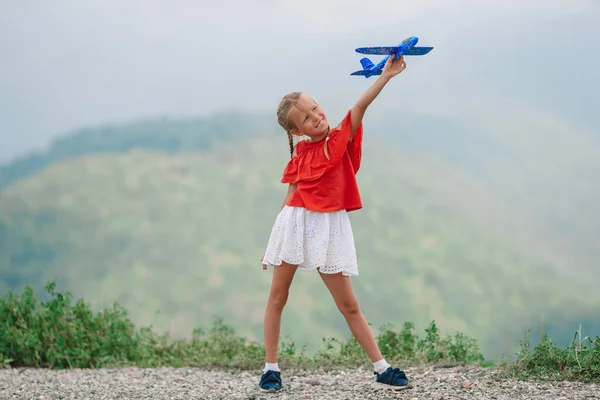 Beautiful happy little girl in mountains in the background of fog — Stock Photo, Image