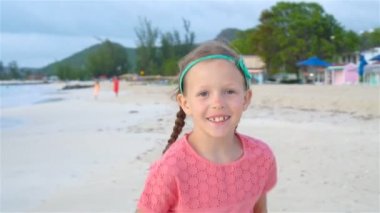 Karayip tatilinde kumsalda şapkalı şirin bir kız.