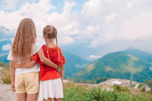 Beautiful happy little girls in mountains in the background of fog — Stock Photo, Image