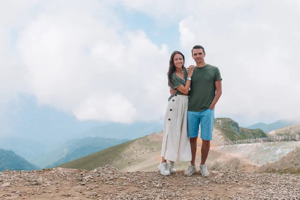 Mooie gelukkige familie in de bergen op de achtergrond van mist — Stockfoto