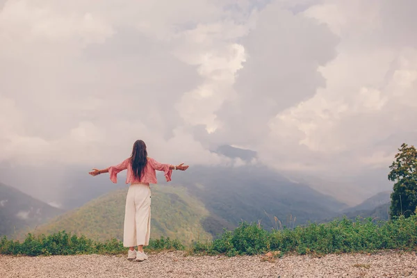 Mulher jovem feliz bonita em montanhas no fundo do nevoeiro — Fotografia de Stock