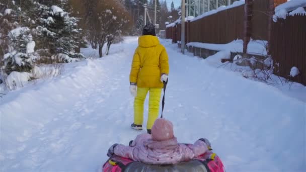Очаровательные маленькие счастливые девочки катаются на санках в зимний снежный день . — стоковое видео