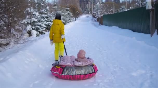 Rozkošné holčičky happy sáňkování v zimě zasněžený den. — Stock video