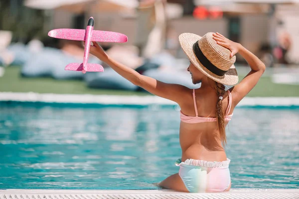 Hermosa niña divirtiéndose cerca de una piscina al aire libre — Foto de Stock