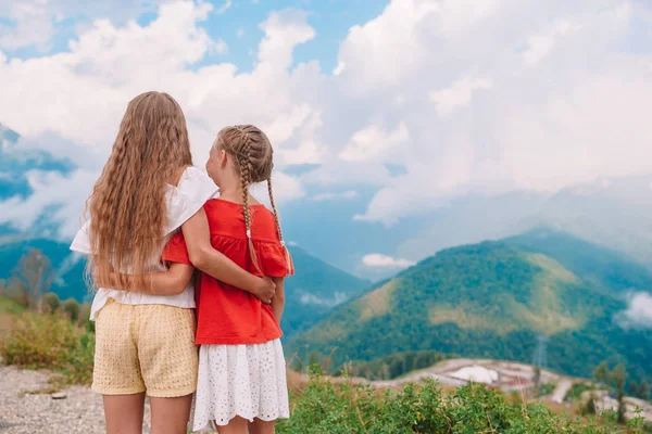 Beautiful happy little girls in mountains in the background of fog — Stock Photo, Image