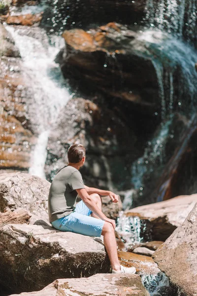 Man enjoying view of waterfall in gungle — Stock Photo, Image