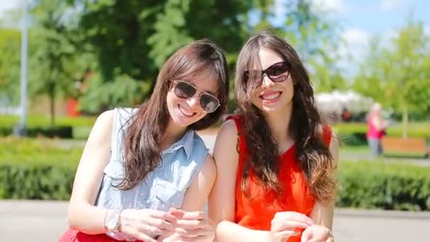 Vackra unga kvinnor porträtt utomhus. Porträtt av glada vackra flickor ler i parken — Stockvideo